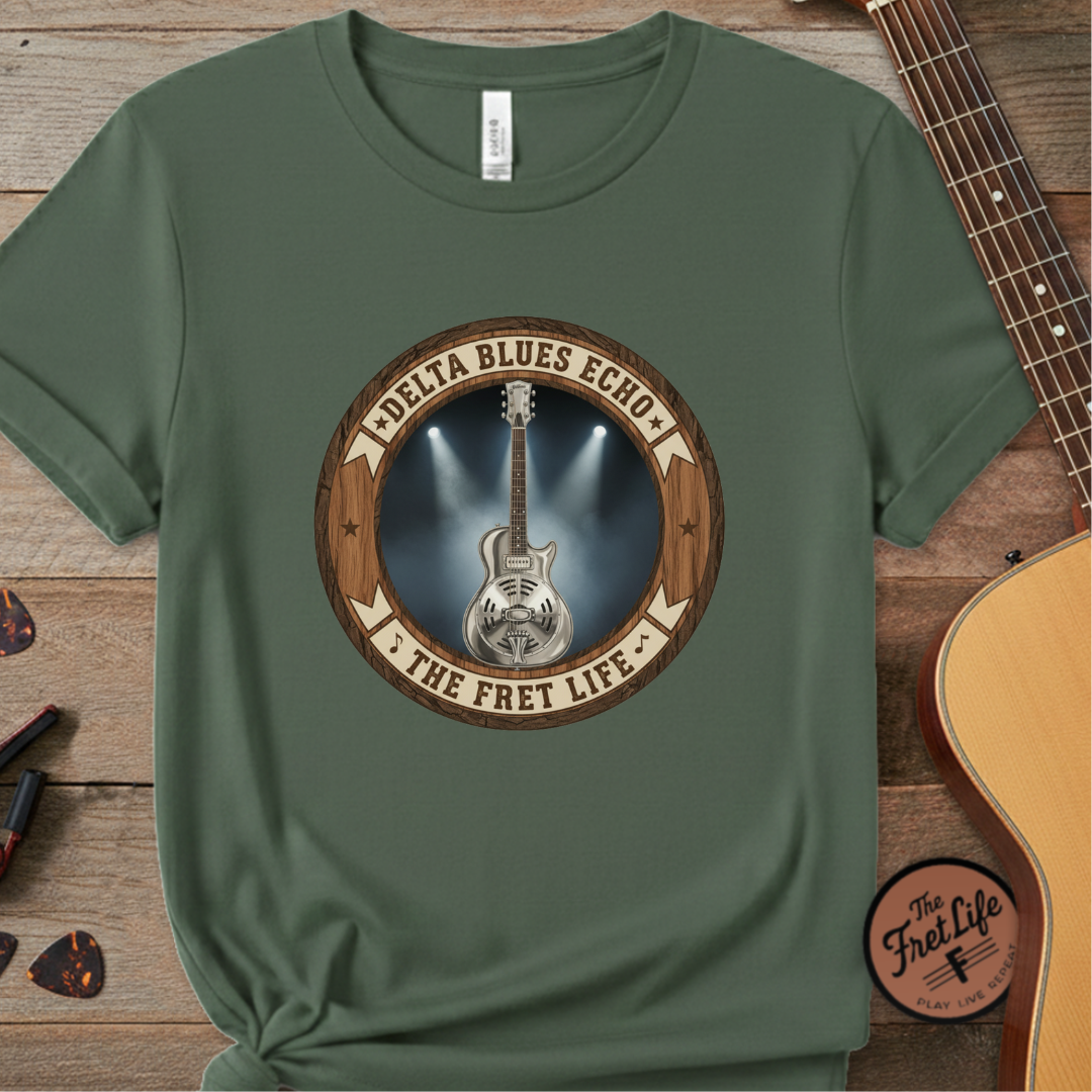 Green t-shirt with guitar graphic and 'Delta Blues Echo' text on a wooden surface with a guitar.
