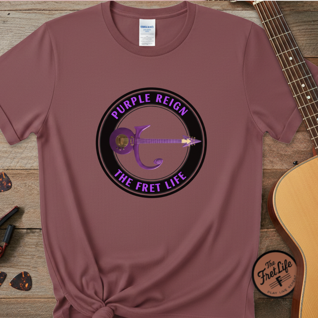 Maroon t-shirt with 'Purple Reign The Fret Life' graphic on a wooden surface with a guitar.