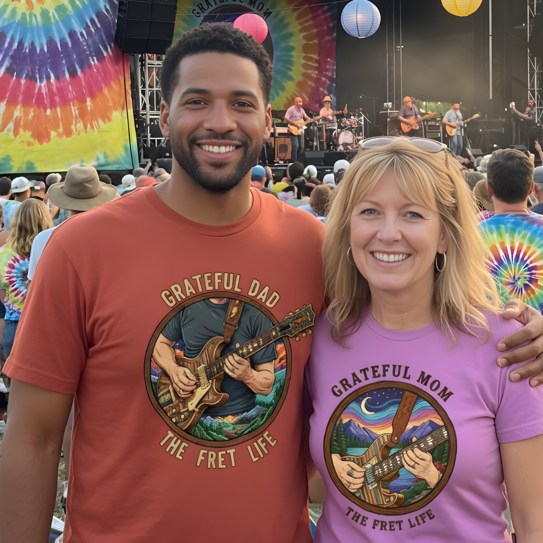 Two people wearing 'Grateful Dad' and 'Grateful Mom' t-shirts at a concert with tie-dye backdrop.