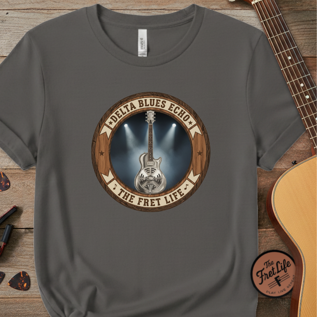 Gray t-shirt with guitar graphic and 'Delta Blues Echo' text on a wooden surface with a guitar.