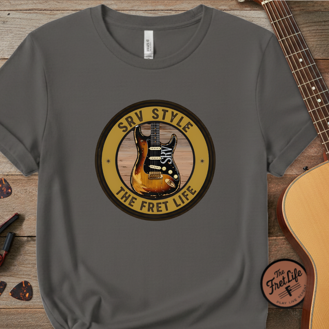 Gray t-shirt with guitar graphic and 'The Fret Life' text on a wooden surface with a guitar.