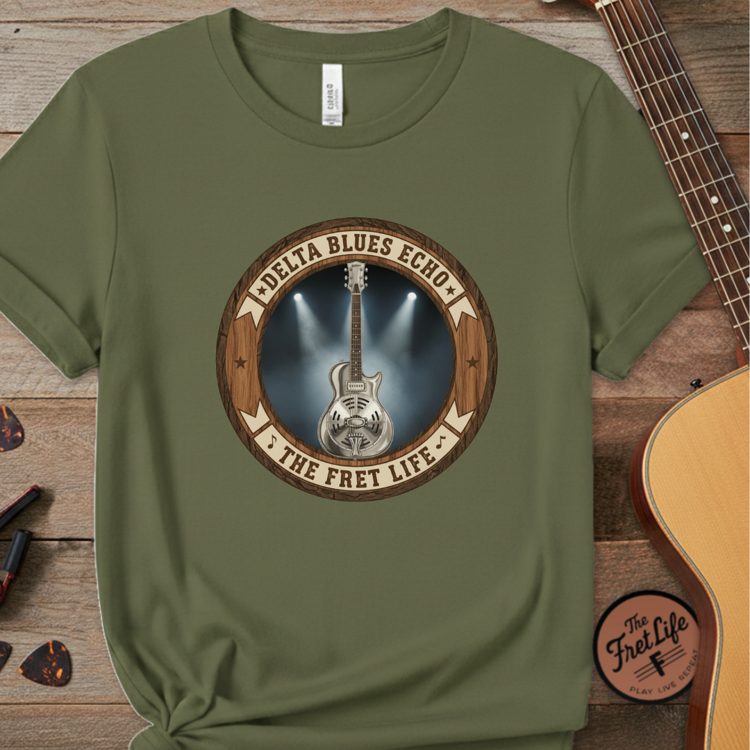 Green t-shirt with guitar graphic and text on a wooden surface with a guitar.