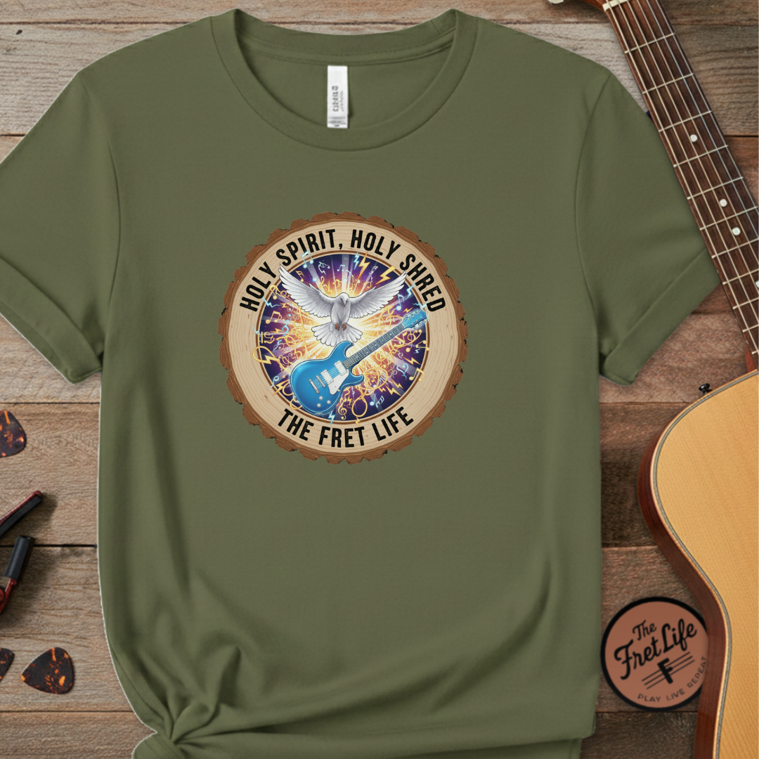 Green t-shirt with a colorful graphic and text on a wooden surface with a guitar.