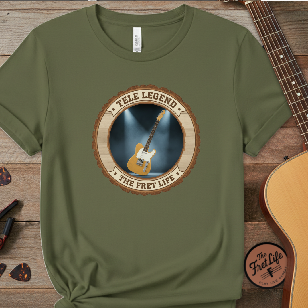 Green t-shirt with 'Tele Legend' graphic on a wooden surface with a guitar