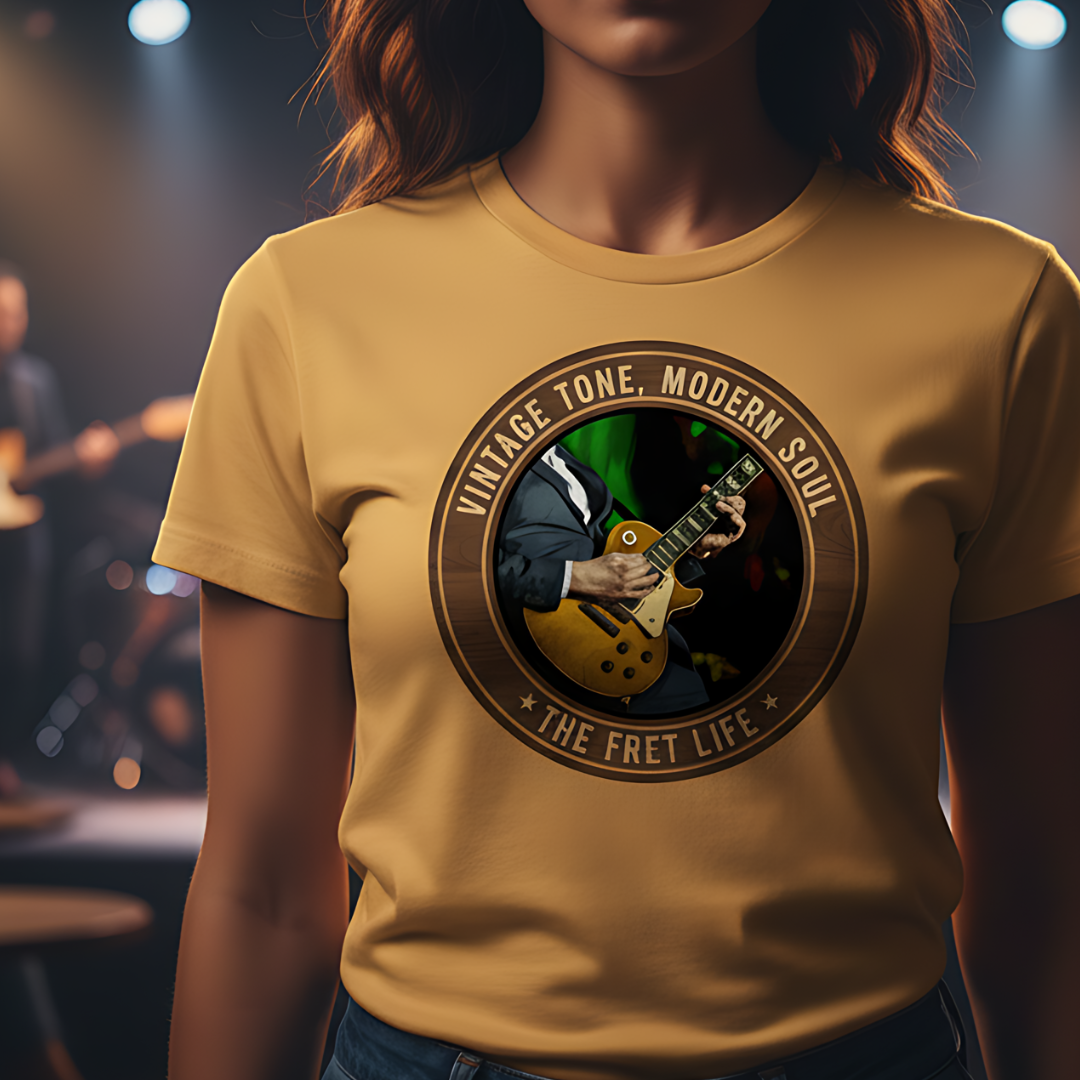 Person wearing a yellow t-shirt with a guitar graphic and text in a concert setting