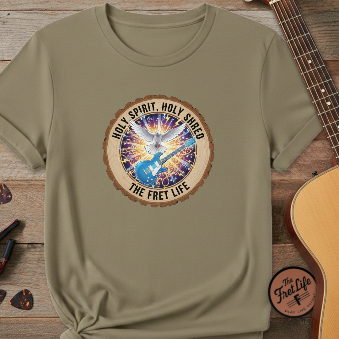 Green t-shirt with a colorful graphic design on a wooden surface with a guitar.