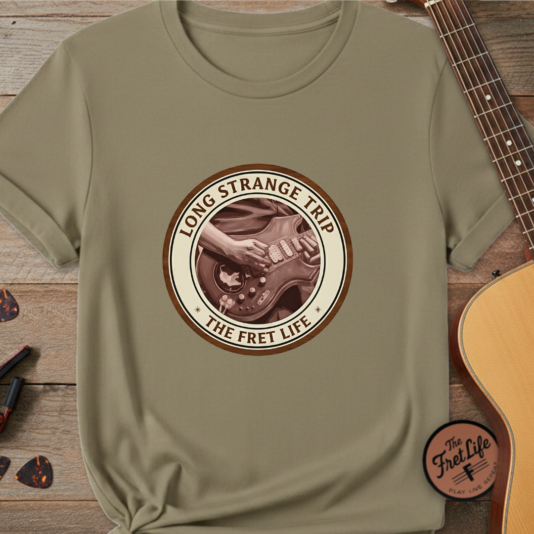 Green t-shirt with 'Long Strange Trip' graphic on a wooden surface with a guitar