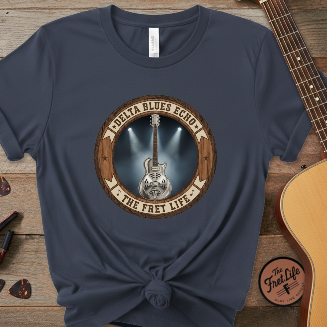 Navy blue t-shirt with guitar graphic and 'Delta Blues Echo' text on a wooden surface with guitars.