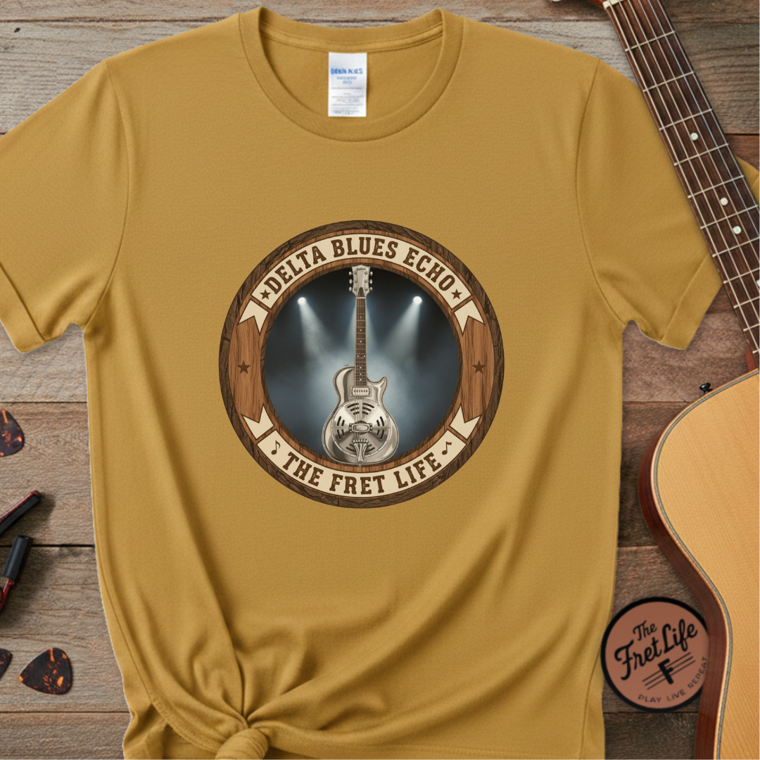 Yellow t-shirt with guitar graphic and text on a wooden surface with a guitar.