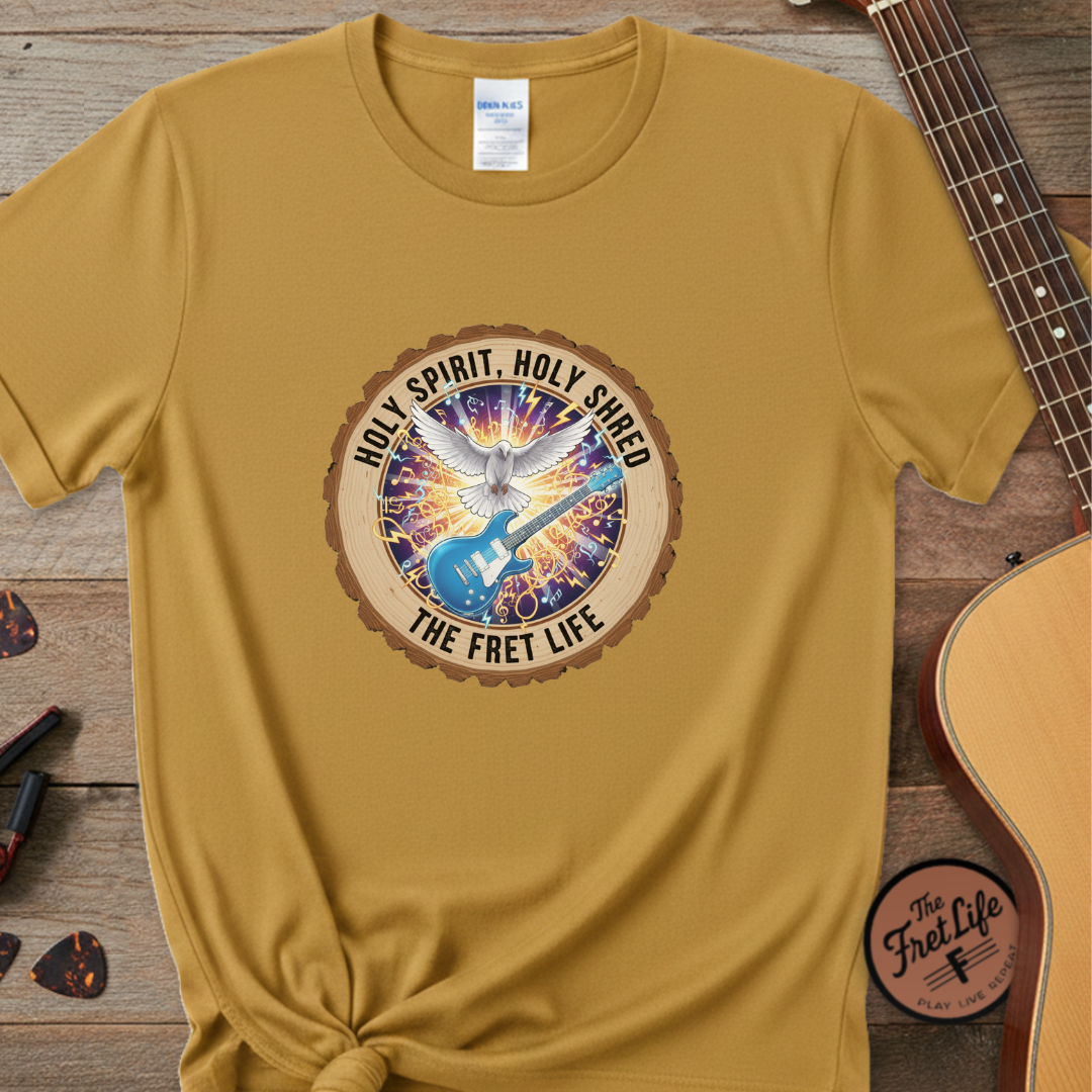 Mustard yellow t-shirt with a colorful graphic and text on a wooden surface with a guitar.