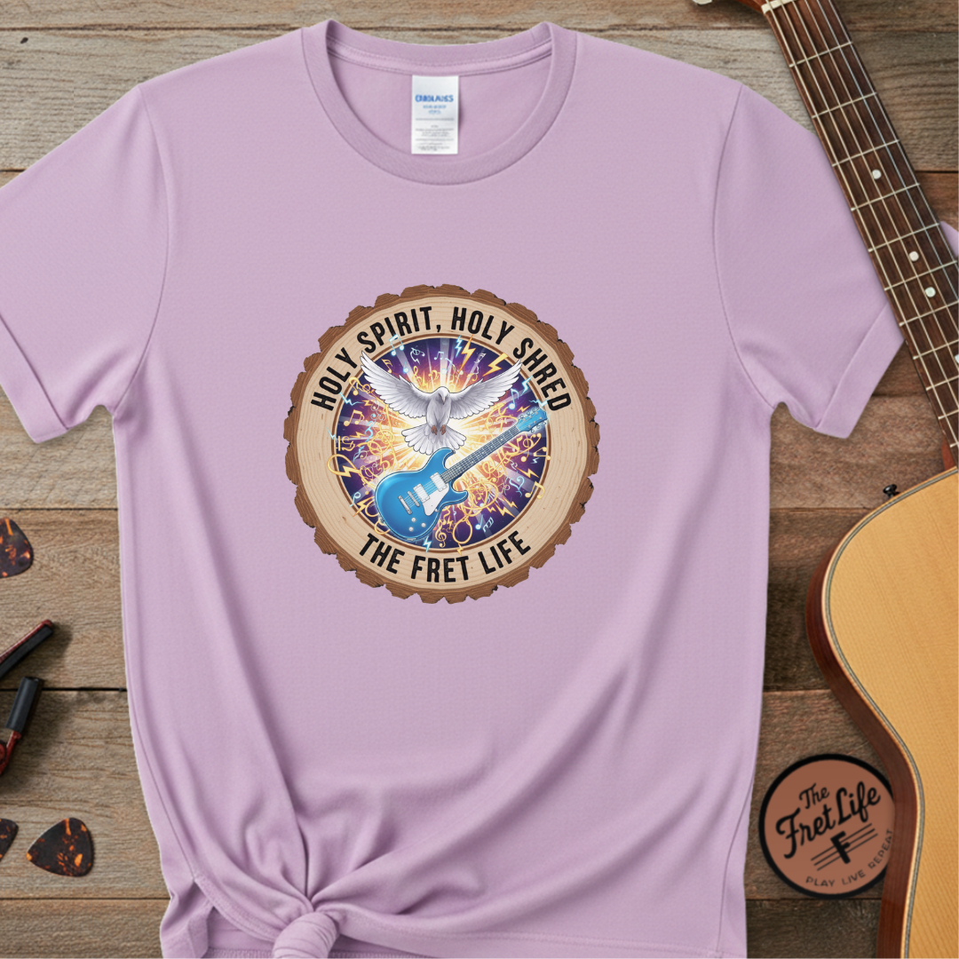 Purple t-shirt with a colorful graphic design on a wooden surface with a guitar.
