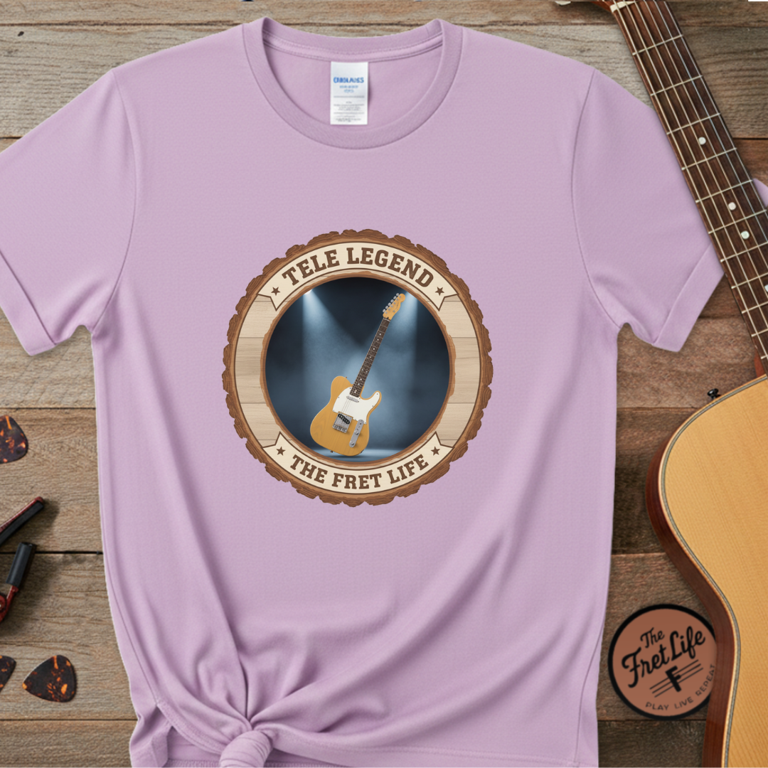 Purple t-shirt with 'Tele Legend' graphic on a wooden surface with a guitar.