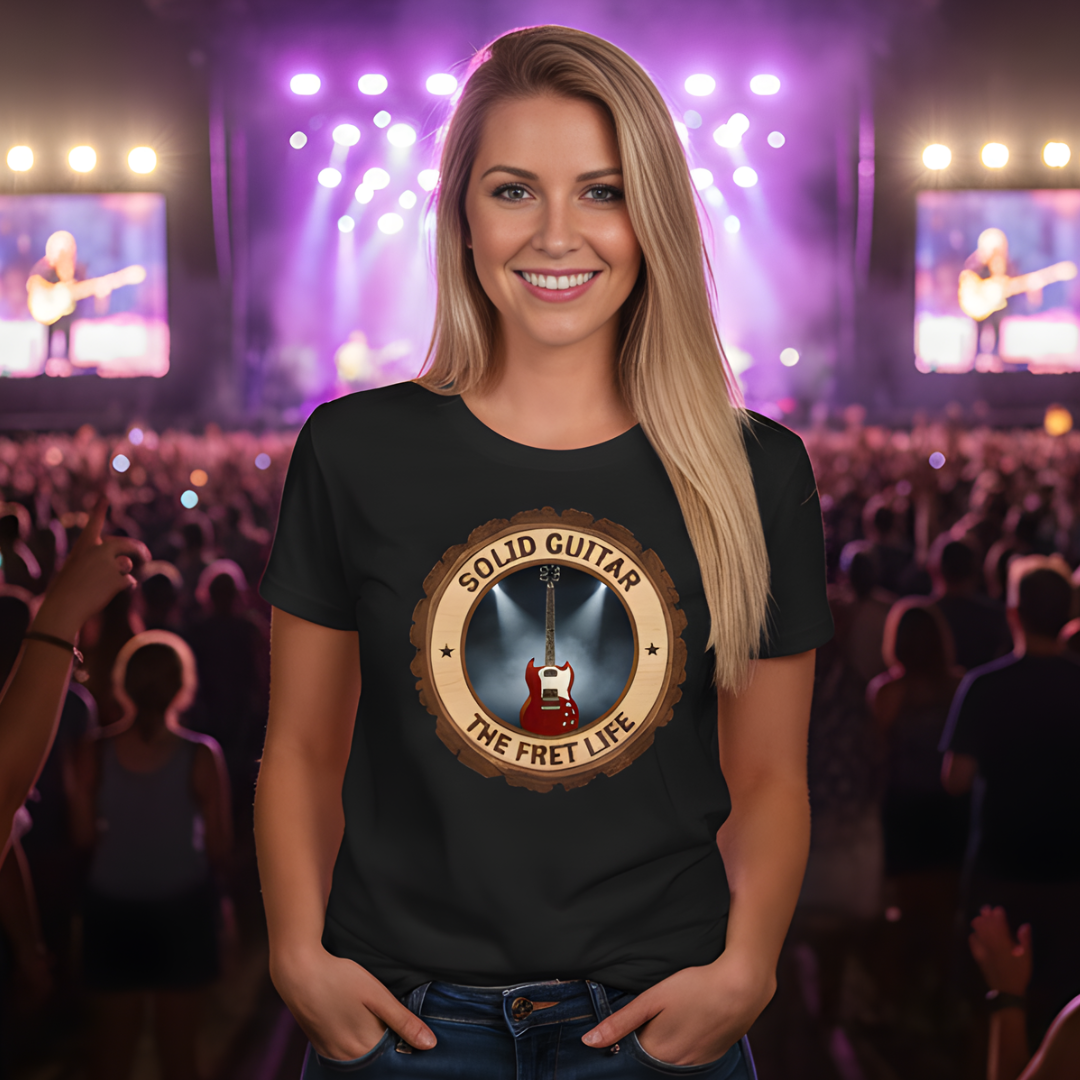 Woman wearing a black t-shirt with a guitar design and text, standing in front of a concert crowd.