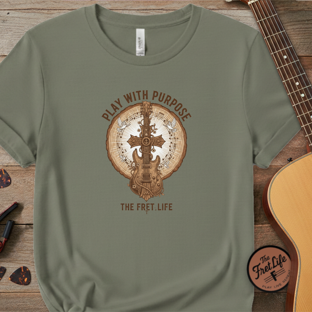 Green t-shirt with guitar graphic and text on a wooden surface with a guitar.
