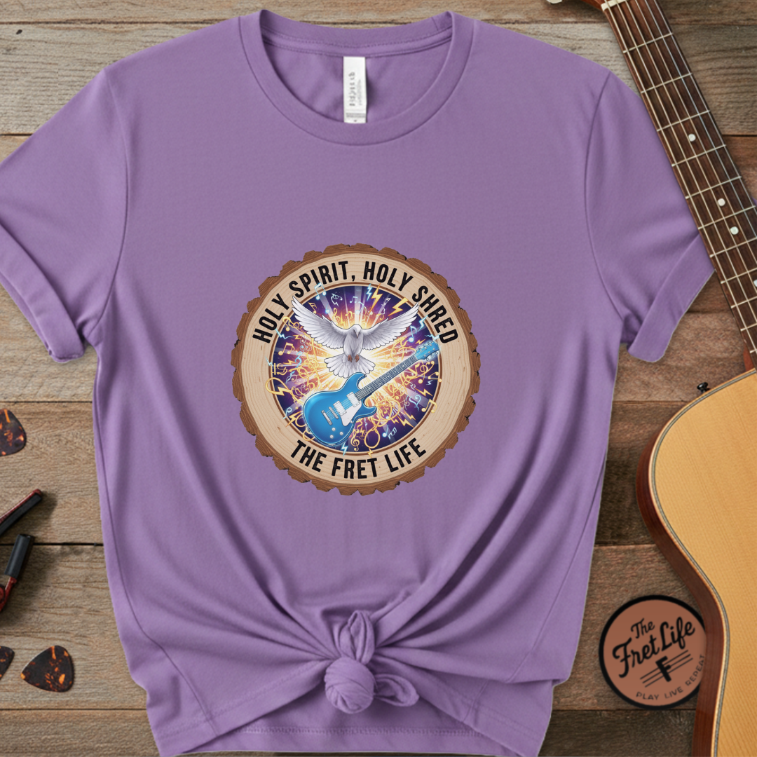 Purple t-shirt with a graphic design on a wooden surface with a guitar